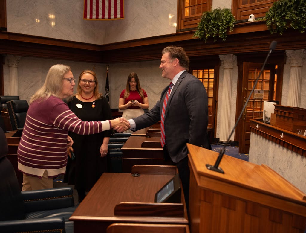 An IFRW member shaking hands with an Indiana legislator in the Senate chamber