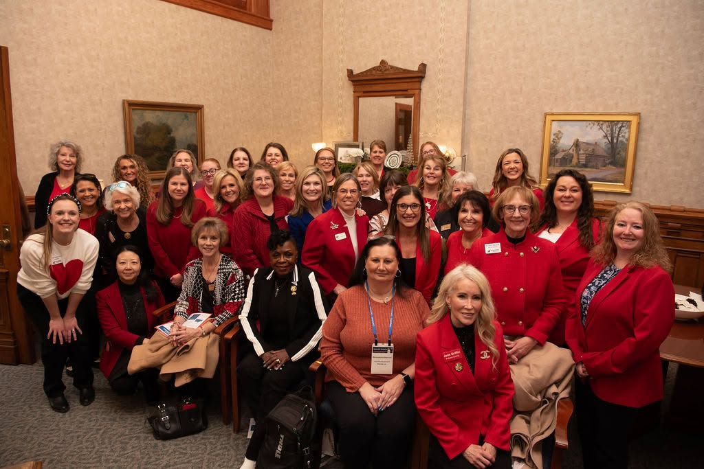 A large group of IFRW members in red gathered in a Statehouse reception room